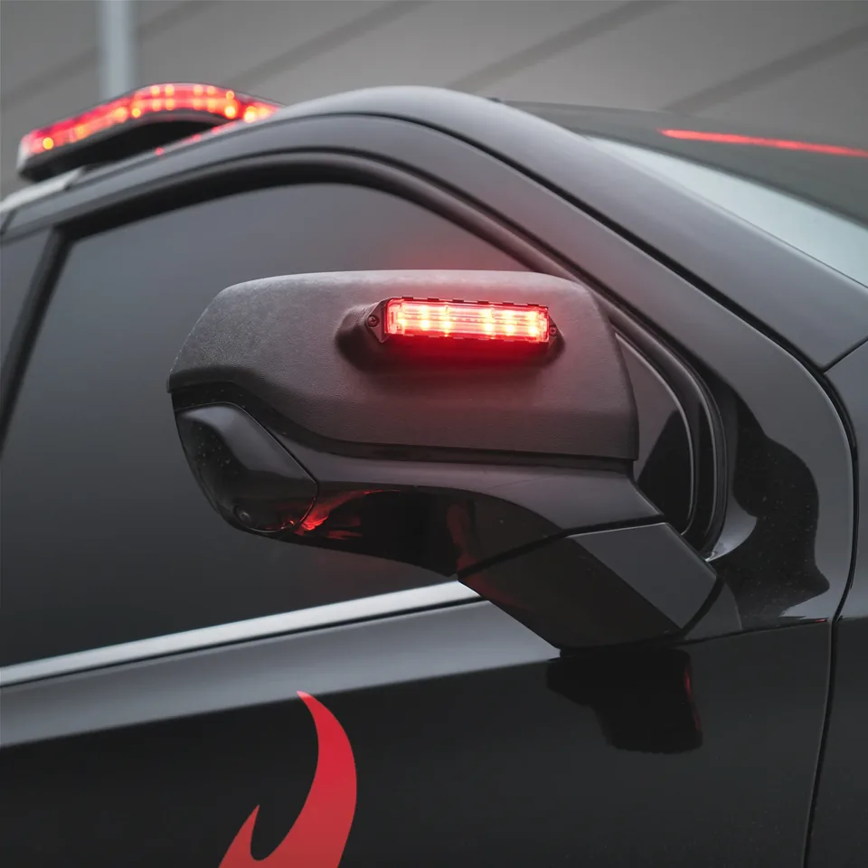 Q Series mirror mount light lit red on a dark vehicle mirror