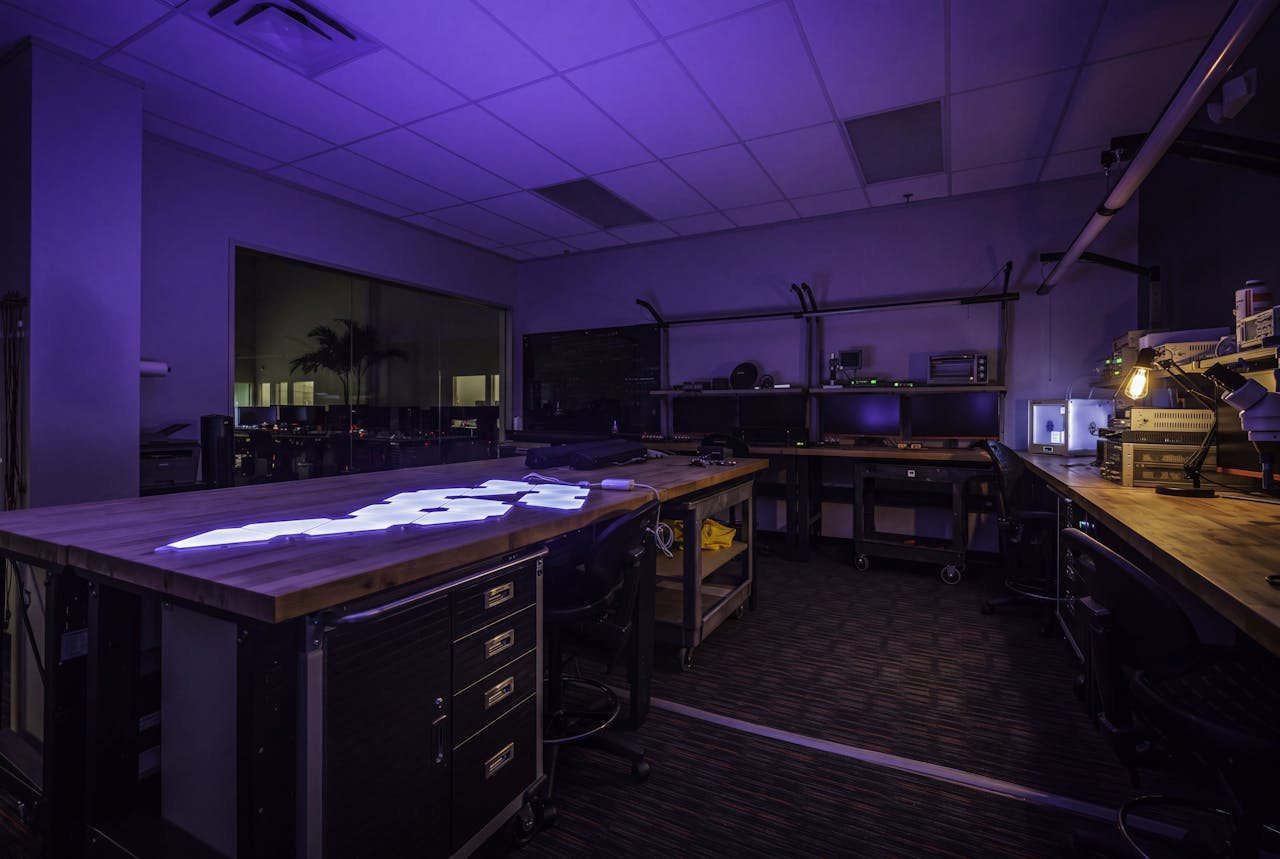 The Feniex engineering lab at night, an illuminated LED panel array on the bench lighting the room.