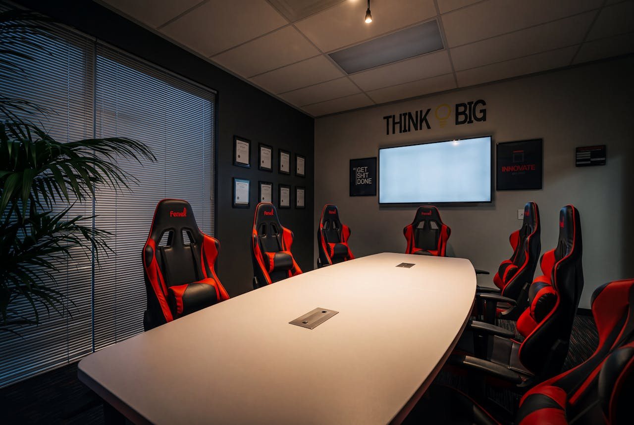 The Feniex conference room in the evening, red chairs around a lit table beneath a wall of framed United States patent certificates.