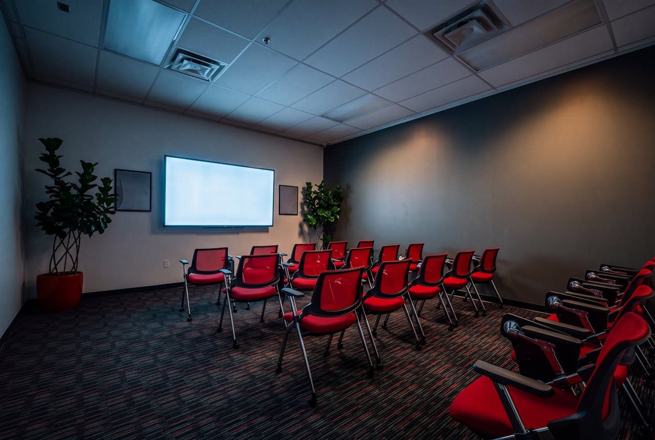 The Feniex training room mid-session, the screen throwing cool light across rows of red chairs.